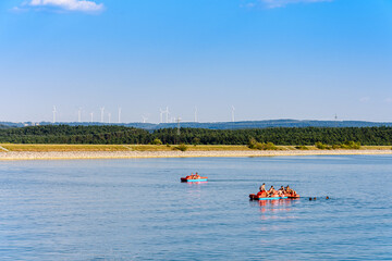 Badespaß am Großen Brombachsee vor Windkraftanlagen am Horizont