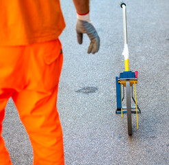 Worker measures the distance with an odometer between the sewer wells. Selective focus