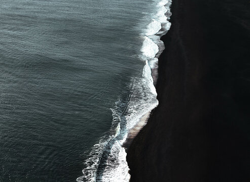 View of black sand beach Atlantic ocean waves in Iceland.
