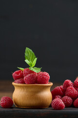 Ripe red raspberries on a brown wooden board