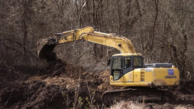 Working with backhoe by digging ground at construction site. Excavator bucket teeth for delve soil. Digging crawler dredge on soil. Digger. Earthmoving vehicle.
