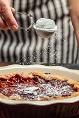 plum pie powdered sugar is sprinkled on the cake. Cut pieces of pie on plate. Food recipe...