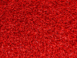 Texture of the red synthetic grass rug as a background