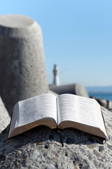 Holy Bible open in beautiful seaside landscape
