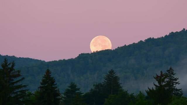Super moon setting behind mountains 