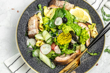 salad with smoked red fish with fresh vegetables, lettuce leaves on a white background, Food recipe background. Close up