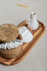 Сotton buds in wooden box with round facial cotton pads