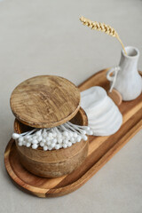 Сotton buds in wooden box with round facial cotton pads