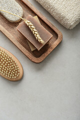 Natural soap bars, wheat spikelet and pumice stone on wooden tray