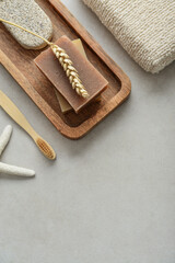 Natural soap bars, wheat spikelet and pumice stone on wooden tray
