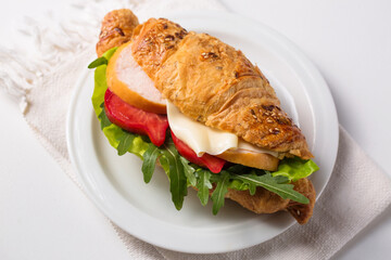Crispy croissant with ham and cheese on a plate