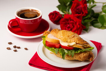 Crispy croissant with ham and cup of coffee