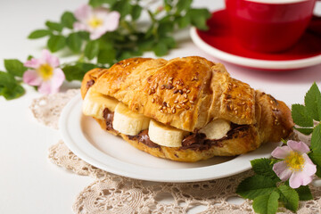 Still life with croissant with peanut butter and banana