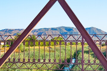 Nice landscape with an old metal bridge that crosses over the Segura River that carries water to irrigate the garden of Murcia	