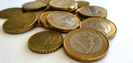 Euro coins on a white background. Money background. Euro currency in Europe. One euro, fifty cents, twenty cents and ten cents. Euro coins in a spoon.
