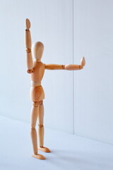 Concept of making the stop signal with the figure of a wooden boy	