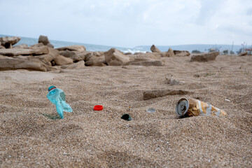 Garbage on a beach left by holiday-makers, environmental pollution concept picture. Sand, sea, sky...