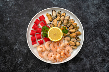 Seafood charcuterie plate board with shrimps, dark background, top view