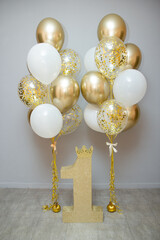 golden and white balloons with helium, holiday decoration with balloons, golden number one, first...