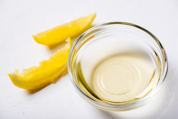 Lemon juice in a bowl. Essence. Lemon slices. White background.