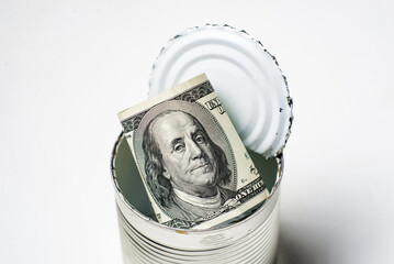 Dollars in an open tin can. Safeguarding cash, stash concept. Time to get the deferred, accumulated...