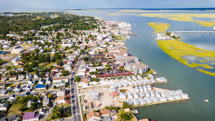 Chincoteague Island, marinas, houses and motels with parking lots. bridge and road along the bay....