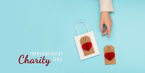 Red Paper Hearts, Woman Hand on Blue Background. International Day of Charity, September 5.