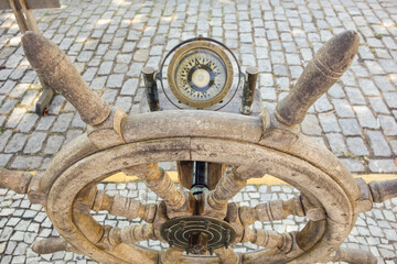 Fototapeta na wymiar Ship steering wheel, old wooden helm and compass