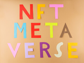 NFT METAVERSE text on a beige background. Inscription Nft Metaverse with multi-colored paper letters. Metaverse, virtual reality and blockchain technology