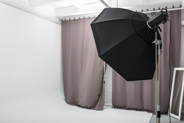 interior of bright space of photo studio with large white cyclorama with lighting equipment