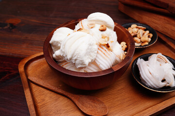 Coconut milk ice cream cup, round balls and young coconut Garnish with cooked roasted peanuts. (spot focus)