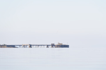 Old derelict wooden jetty pier in sea at Inverkip power station