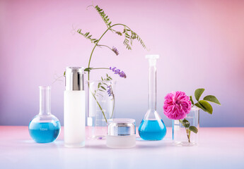 cosmetic containers, laboratory beakers, a rose and a sprig of mouse peas on a gradient background....