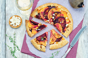 Sweet potato beets galette with goat cheese and thyme on a wood background