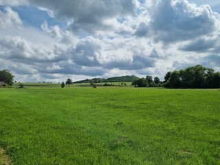 Naklejka premium green land under a painting of clouds: landscape near Amecke, Sauerland, North Rhine-Westphalia, Germany