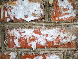 Abstract texture background. Brick wall with exposed bricks and old torn street posters. Design element