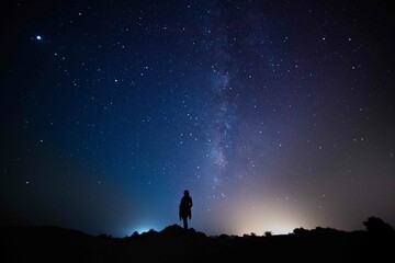 Milky Way. Night sky with stars and silhouette of a standing happy person with yellow and blue ...