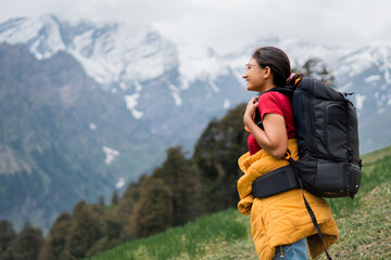 Teenager Indian girl hiking on mountain with backpack in Manali, Himachal Pradesh, India. Female...