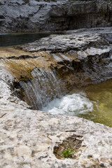 Natural path of Val Falcina at Valle del Mis in Italy. Cadini of Brenton, Sospirolo, with blue azure clear water and multiple waterfalls along the way down