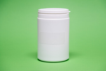 White plastic jar on a color  background with empty label for text for food or dietary supplements