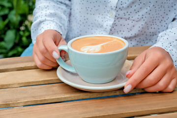 Fototapeta na wymiar female hands hold a cup of coffee. cup of coffee close-up