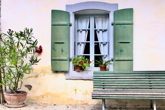 old house with flowers, window and bench