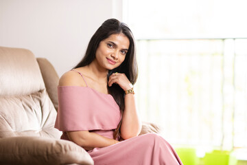 Pretty Indian young woman on sofa at home