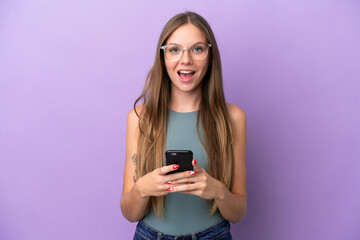 Young Lithuanian woman isolated on purple background surprised and sending a message