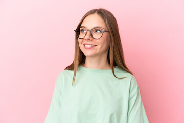 Young Lithuanian woman isolated on pink background With glasses with happy expression