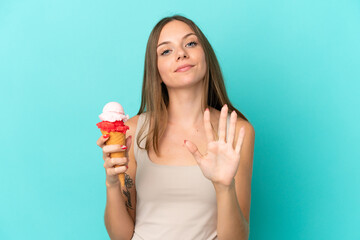 Young Lithuanian woman with cornet ice cream isolated on blue background counting five with fingers