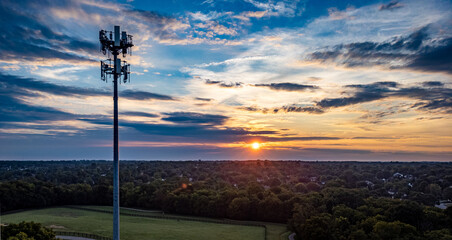 5G mobile cell phone repeater tower on the hill of a park in the mid west city of Lexington, KY during dramatic sunrise.