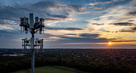 Cell phone tower on the foreground, neighborhoods of Lexington, Kentucky on a distance during early morning sunrise. - Powered by Adobe