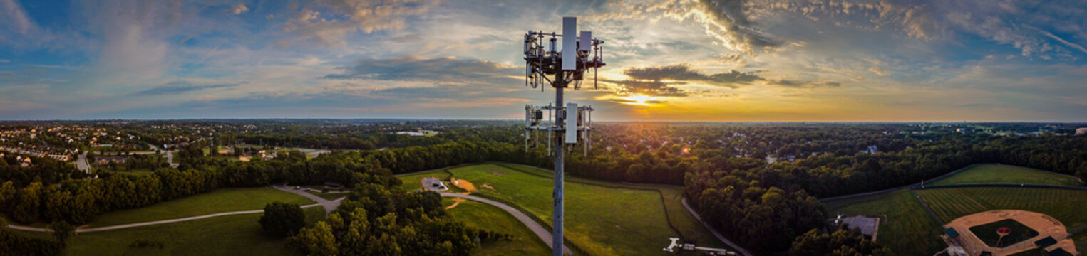 Panorama of mobile cell phone transmission tower on the hill of a park in the mid west city of Lexington, KY during dramatic sunrise.