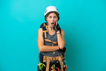 Young English rock climber woman isolated on blue background surprised and shocked while looking right